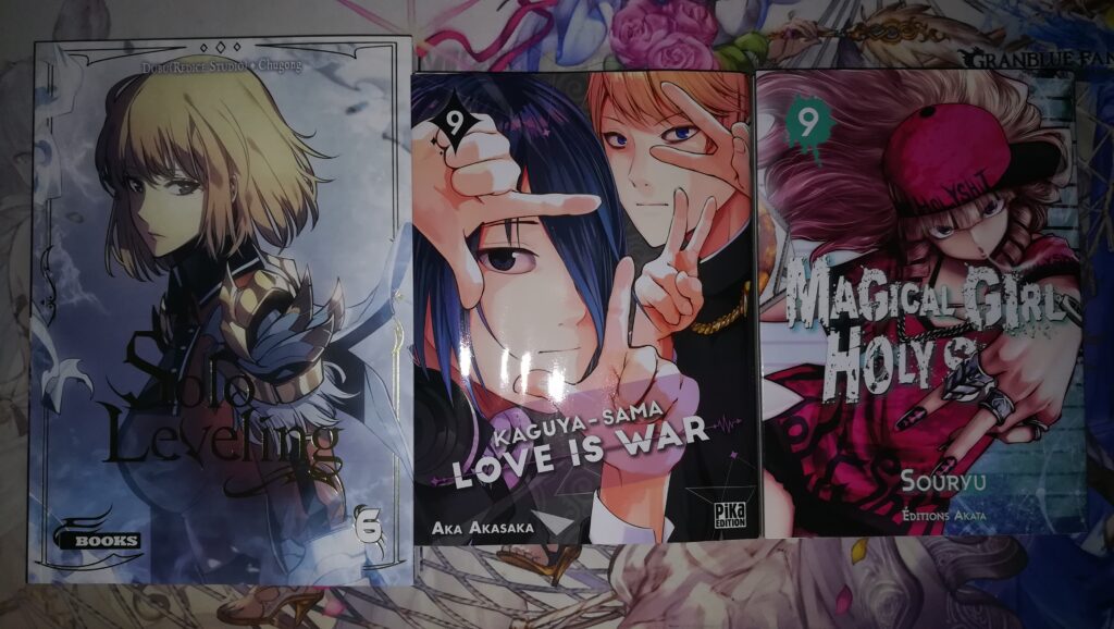 De gauche à droite et le tout en français, le tome 6 du webtoon Solo Leveling, le tome 9 du manga Kaguya-sama Love is War et le tome 9 du manga Magical Girl Holy Shit.